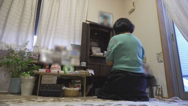 優さんに手を合わせ報告する母親