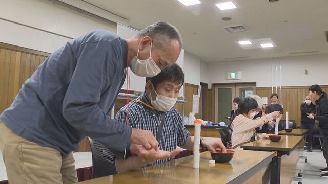 優さんに「てのひら書き」で伝える通訳介助員
